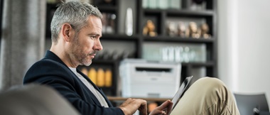 uomo lavora a casa in smartworking con una stampante Brother
