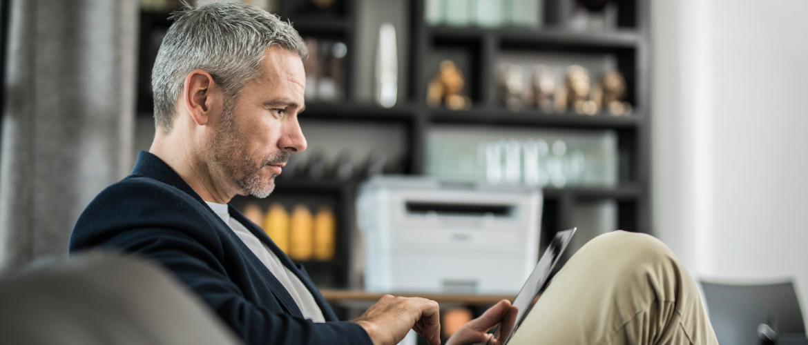 uomo lavora a casa in smartworking con una stampante Brother