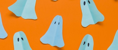 Piccoli fantasmi di carta su sfondo arancione