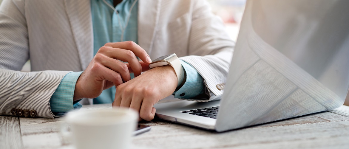 persona alla scrivania controlla email dallo smart watch