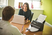Impiegati in ufficio che scannerizzano documenti con scanner desktop Brother ADS-3000N
